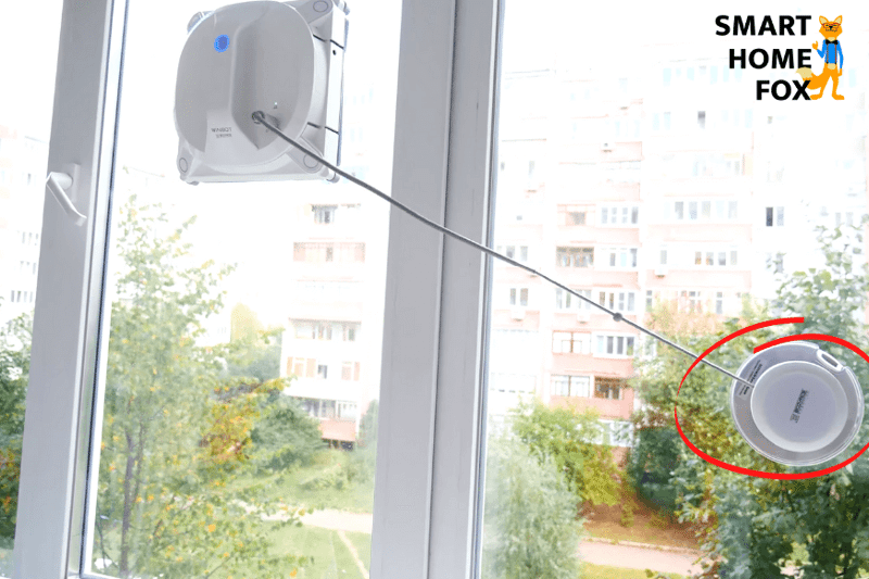 Man sieht den Ecovacs Winbot X, wie er mit einem Saugnapf an der Scheibe gesichert ist.